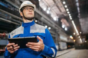 Opérateur utilisant une tablette dans un atelier de production connecté à Odoo Fabrication