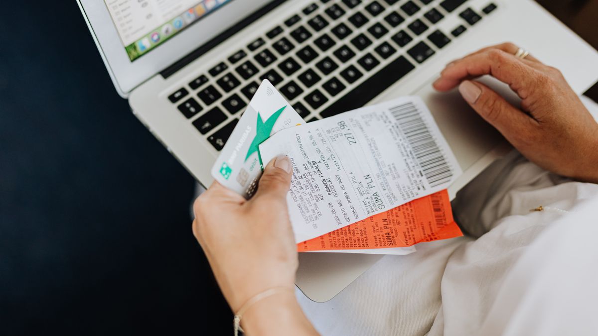 Personne réglant un paiement récurrent en ligne avec une carte bancaire devant un ordinateur